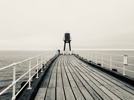 A print of a lone fisherman on the west pier of Whitby.